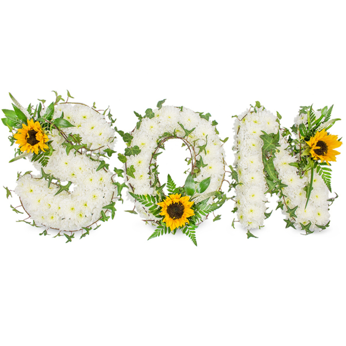 A three-dimensional, lettered funeral tribute clearly forming the word SON, presented on a pure white photographic background so each element reads crisply. Each capital letter is densely surfaced with small, immaculate white chrysanthemums whose clustered heads create a soft, tactile field; the petals overlap to form a continuous, velvety texture across S, O and N. Threaded through this white base are lengths of dark-green ivy with characteristic glossy leaves, weaving around and into the letters to add shadow, contour and an evergreen suggestion of remembrance. Complementary foliage-feathered fern fronds and assorted pointed leaves in lighter green-introduces layered depth and a natural silhouette that prevents the composition from appearing flat. Strategically placed to draw the eye are three vivid sunflowers: one tucked into the upper-left curve of the S, another positioned low at the O's inner curve amid fronds, and the third anchored at the upper-right corner of the N. Their bright yellow rays surround textured dark-brown centres, creating warm focal anchors against the white chrysanthemum field. The lighting is neutral and soft, chosen to accentuate texture without strong glare, and the photograph's composition emphasises the bespoke, commemorative nature of the design. For families arranging tributes in Kennington or nearby Vauxhall and the Oval, this arrangement reads as a carefully balanced expression of respect-white for peace, green for life's renewal, and sunflower gold for the memory's warmth.