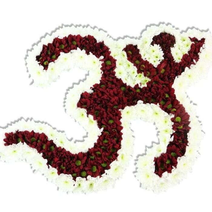 This image shows an intricately assembled Om (Aum) symbol fashioned entirely from clusters of compact, small-headed chrysanthemums, photographed against a stark white background so every contour is crisply visible. The interior of the symbol is a rich field of maroon-to-deep-red blooms - a velvety wash whose surface is animated by countless tiny green centres that peek from each blossom, adding a subtle, organic contrast. Encircling and defining each loop and negative space is a robust rim of clean white spray chrysanthemums, their tiny petals forming a soft, luminous halo that highlights the Sanskrit form: the characteristic '3'-shaped curve, the descending S-like sweep, and the small crescent with its dot above. The volumetric construction casts a modest shadow beneath, signalling the arrangement's three-dimensional build and the floristry skill required to achieve such consistent density and shape. Descriptively tactile, the petals read cool and silky, the overall impression grounded by a faint, earthy scent that calls to mind a late-summer market stall of cut flowers. Intended as a devotional or commemorative piece, this floral Om would serve at cultural festivals, temple offerings, meditation sessions, or funerary tributes; locally, it would resonate with families and community groups around Kennington Park, Kennington Lane and the nearby Oval, where ceremonial floral work is often requested. The piece communicates reverence through colour, texture and meticulous hand-placed blooms, marrying spiritual symbolism with practiced local florist craft.