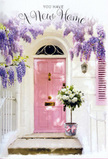 The scene shows a peaceful Kennington doorway that has been gently transformed by flowers into a symbol of new beginnings and heartfelt welcome. At its centre, a pale pink front door stands slightly recessed, its colour delicately warm, like the soft blush of dawn over the nearby Kennington Park. Surrounding the door, a generous curtain of lavender wisteria cascades from overhead, the blooms hanging in loose, fragrant clusters that frame the entrance like a natural garland. The whitewashed wall and a softly painted shutter to one side catch the diffused city light, with shadows of leaves and petals dappling their surface, giving a sense of a mild afternoon with the slightest breeze. At doorstep level, a smart grey florist's bucket has been placed with intention, as though just delivered by hand from a local SE11 flower shop. It overflows with velvety white and cream roses, each bloom open and full, their rounded forms nestled together with sprigs of soft green foliage to create a lush, welcoming texture. Around the bucket, a pink ribbon is tied in an easy bow, its satin finish catching the eye and linking the arrangement visually back to the pink of the door. The mood is quiet yet deeply uplifting: the flowers suggest a housewarming gift, a surprise left on the step to greet the new residents as they cross the threshold for the first evening in their home. Every detail-from the pastel palette to the cascading vines-combines to evoke a sense of comfort, optimism, and the gentle joy of starting a new chapter in Kennington.